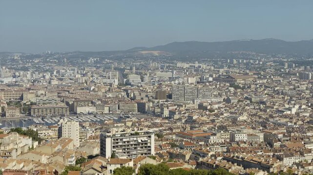 Expansive aerial panorama of Marseille's urban landscape, featuring the Old Port and city buildings