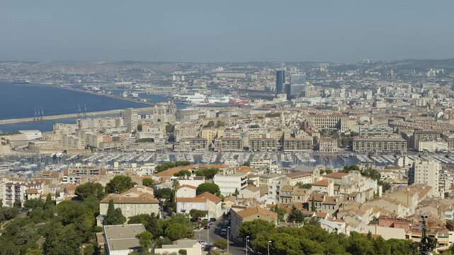 Expansive view of Marseille, showing the city, the Mediterranean Sea, and the bustling port area