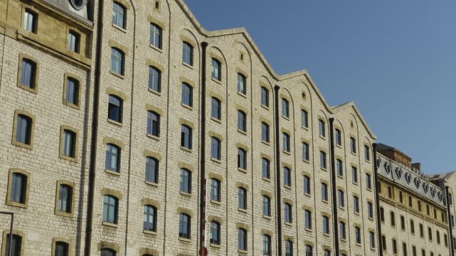 Low angle view of the historic facade of Les Docks de Marseille against a clear blue sky
