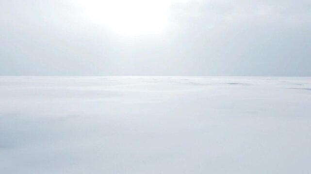 Endless white snow field under bright winter sky