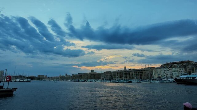 Panoramic view of the Vieux Port of Marseille in France with boats docked under a cloudy sky