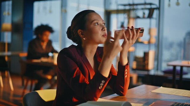 Corporate manager recording voice message phone. Businesswoman speaking office.