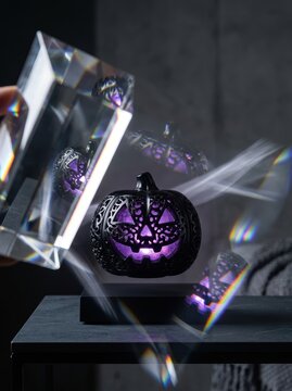 Prismatic refraction of a levitating black lace jack-o-lantern with purple glow for spooky Halloween home decor.