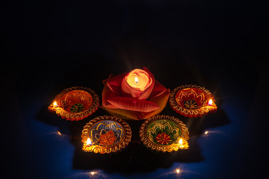 Diwali festival glowing diya lamps and lotus candle in the dark.