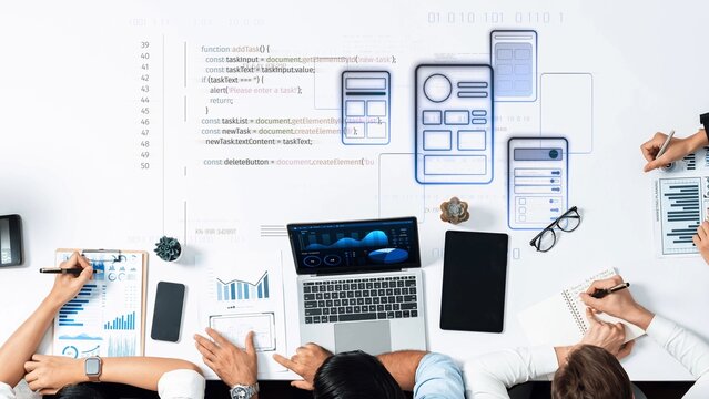 A diverse team collaborates over data analysis and web development, using laptops and documents to brainstorm ideas and strategize for project success. Raster