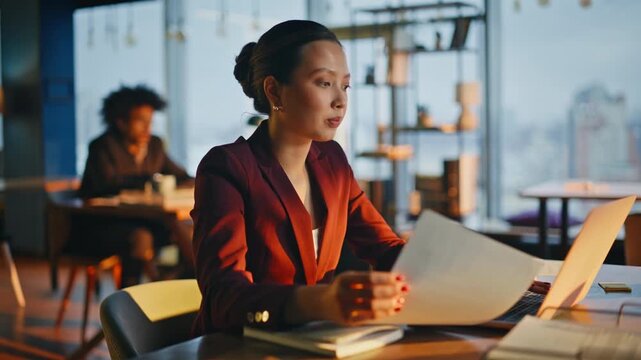 Corporate lawyer reading report office desk. Analyst reviewing document laptop.