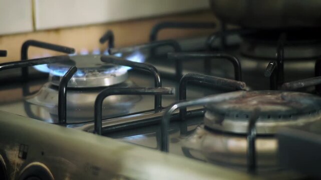 Close Up of Gas Stove Igniting Flame and Pot Being Placed to Cook - 4K