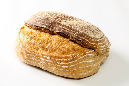 A rustic artisan sourdough bread loaf isolated on a clean white background.  The texture of the crust highlights the handcrafted baking process and natural fermentation typical of sourdough bread.