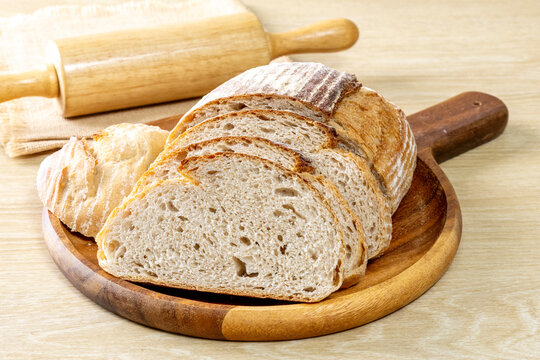 Sliced Sourdough Bread isolated on  Wooden Background, Homemade Bakery Concept