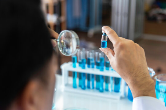 Scientist, or researcher in a laboratory holding a magnifying glass looking .concept study of the virus background