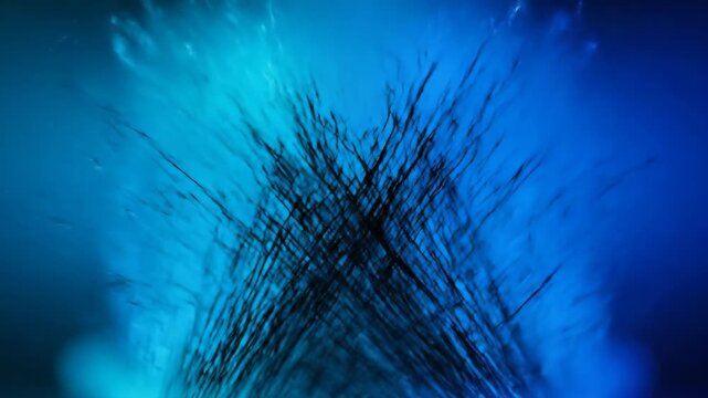 Macro shot of dark bristles moving against a vibrant blue gradient background.