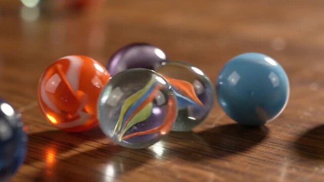 Colorful glass marbles rolling on a wooden table surface