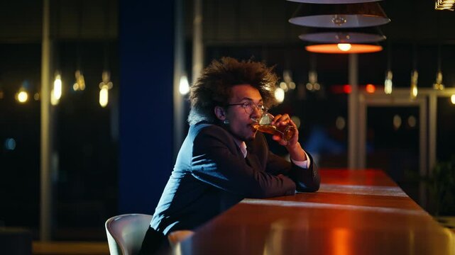 Man drinking beer alone bar counter night. Pensive guy waiting evening pub.