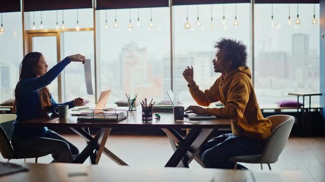 Man passing document woman coworking office. Multiracial team working laptop.