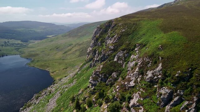 Aerial flight toward the cliffs of Lough Tay along the lakeshore