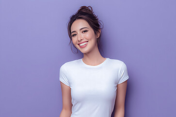 Obraz premium Young Asian woman in a white t shirt posing on a soft pastel background expressing comfort, simplicity, and relaxed home lifestyle.
