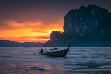 Obraz premium Natural scenery of long-tail boats at the seaside at sunset on Railay Beach, Krabi, Thailand