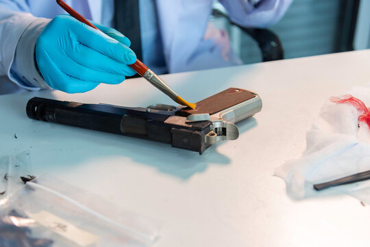 Forensic expert taking blood sample from gun