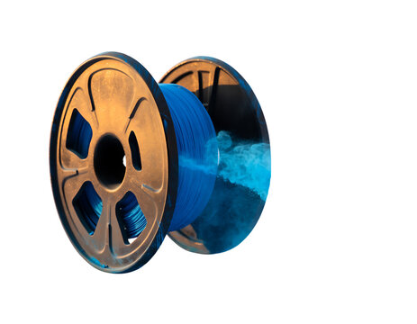 Blue filament spool spinning rapidly with bright colored dust cloud exploding around edge powder.