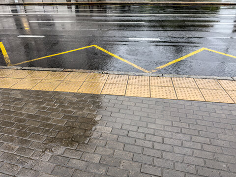 wet city street with reflection of sky and buildings after heavy rain.