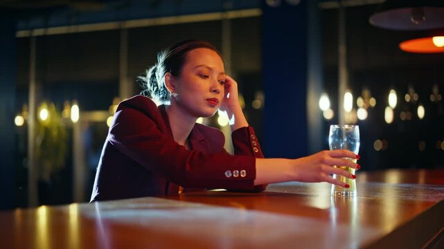 Pensive asian woman sitting bar counter beer glass. Lonely girl thinking night.