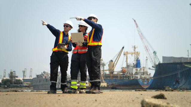 A team of engineers in safety gear walk beside the water at a port inspected the operations of the deep-sea port
