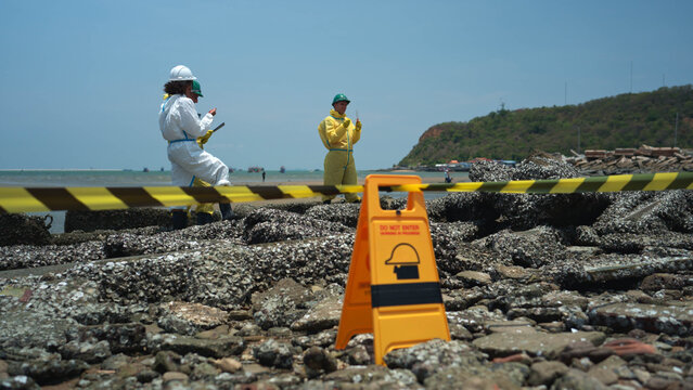Environmental response team in hazmat suits analyzing coastal water samples and monitoring marine pollution