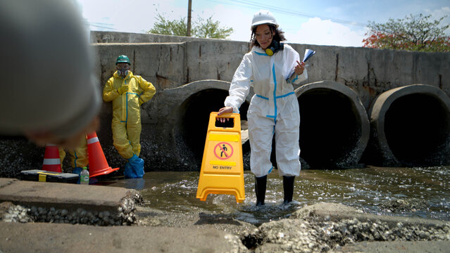 Warning sign and hazardous work area near polluted wastewater drainage tunnel