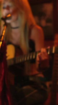 Blurred Bokeh Scene of woman Musician Playing Guitar singing live in Warm Bar nightlife