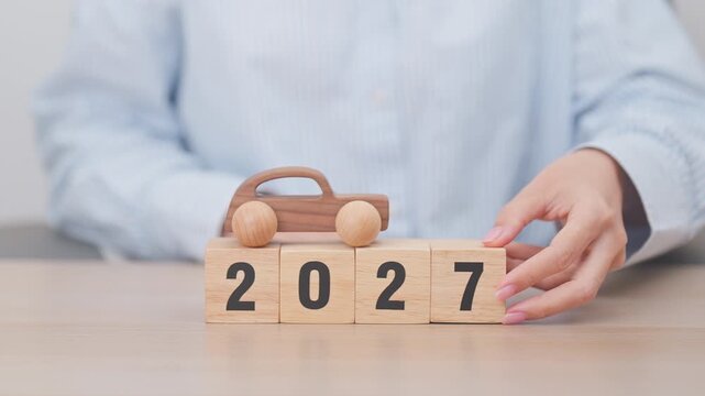 Happy New Year 2027 with Car model on table. Automobile Tax, Car Insurance, Financial, vehicle Repair and Maintenance and New Year concept