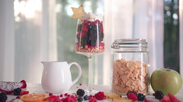 Fresh fruit mix in a glass for breakfast. Granola and muesli blend with berries and milk. Morning breakfast with natural oatmeal and fruit. Healthy lunch. Fruit cocktail served in a stylish glass cup.