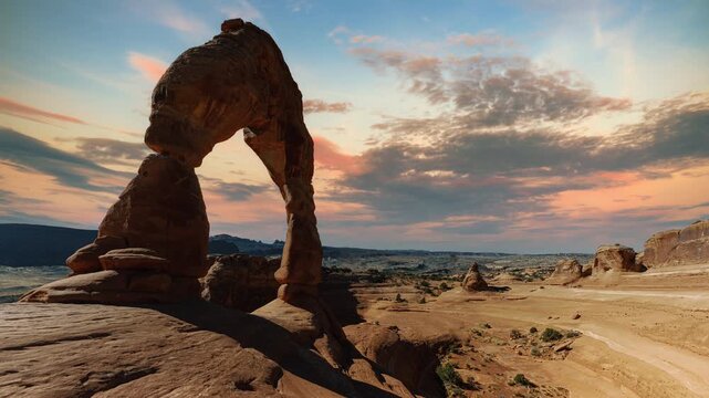 Time lapse video loop of Delicate Arch with sunset cloud sky. Arches National Park landscape, Utah, USA