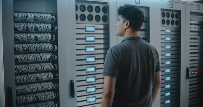 Data Center Engineer Presses Controls on Server Cabinet While Inspecting Equipment Indicators, Demonstrating Hands on Infrastructure Management and Technical Service in Modern Server Facility.