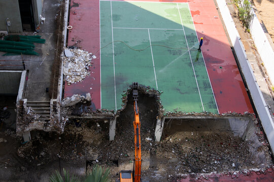 Excavator Demolishing Rooftop Tennis Court Building