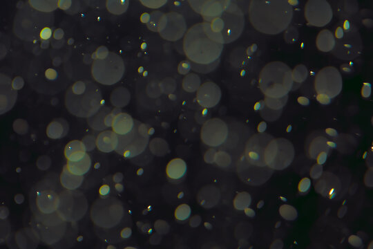 Defocused bokeh lights in various sizes and colors on a dark background creating a dreamy and abstract visual effect
