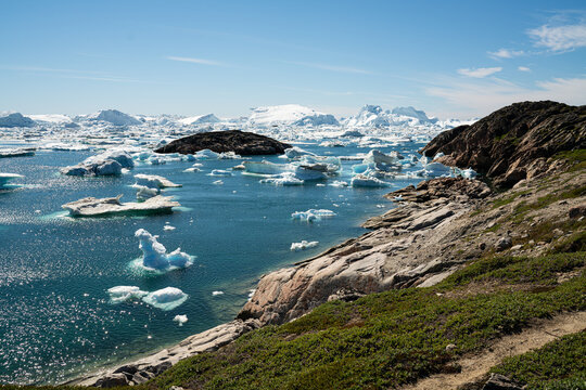 Global Warming and Climate Change. Iceberg from melting glacier in Ilulissat, Greenland. Midnight sun in arctic nature landscape famous as heavily affected by global warming. Panoramic View.