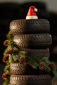 Festive stack of car tyres adorned with a cheerful santa hat in a workshop setting Generative AI