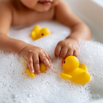 Joyful moments of a baby playing with yellow ducks in a bubbly bath Generative AI