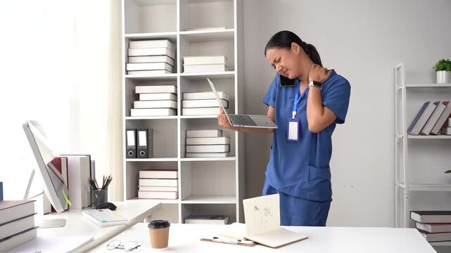 Busy Nurse's Overwhelmed Moment: A nurse is stressed and overworked, talking on the phone, holding a laptop, and rubbing her neck in a cluttered office, reflecting the demanding nature of healthcare.