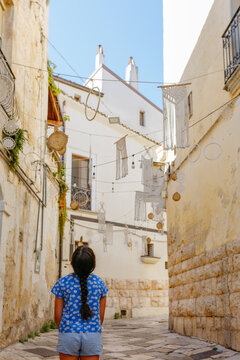 Girl exploring a decorated old town street in Puglia
