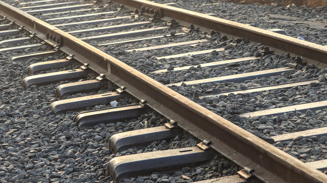 Industrial perspective of empty railway tracks and steel rails on stone ballast for heavy freight and passenger train transportation network