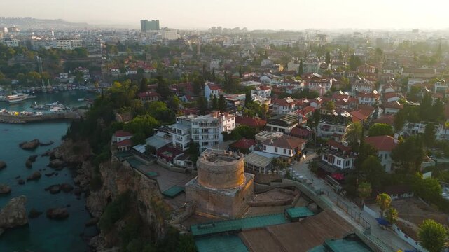 Antalya, Turkey. Hidirlik Tower, a 2nd-century Roman cylindrical stone monument rising from a square base, aerial view at sunrise over the Mediterranean coastline and Kaleici old town. Aerial View, M