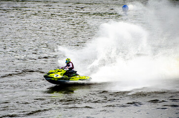 Racer speeding on jet ski carving sharp turn through splashing water. Racing at high speed, adrenaline mood, open water course, extreme watersport action concept © Vivid Impressions LT