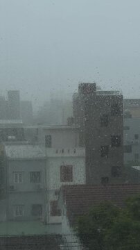 A cityscape shrouded in heavy rain and fog. Buildings are partially obscured, creating a moody atmosphere. The scene conveys a sense of urban isolation.
