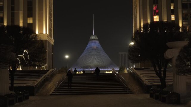 Night view of the Khan Shatyr Entertainment Center illuminated with neon lights in winter. 
