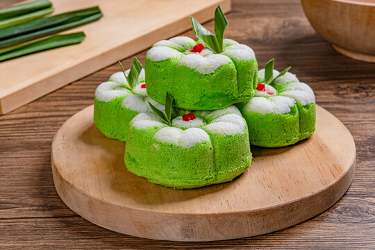 Traditional indonesian green kue putu ayu pandan steamed cake with coconut on wooden board