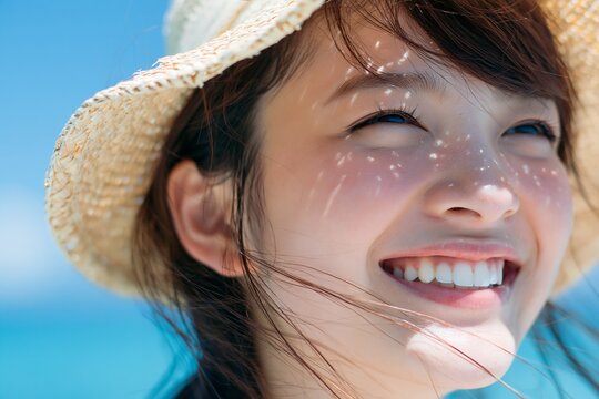 夏の太陽光を浴びた麦わら帽子の女性の幸せな笑顔
