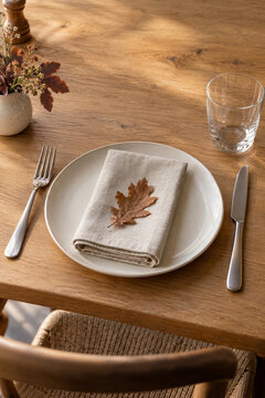 Herbstliches Tischgedeck mit Leinenserviette und Eichenblatt