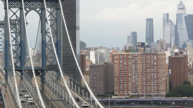 Manhattan bridge from above, rooftop in Brooklyn Dumbo, New York, United States. City traffic on transport bridge aerial view, cars on road. Hudson Yards district skyscrapers, towers on rainy day.