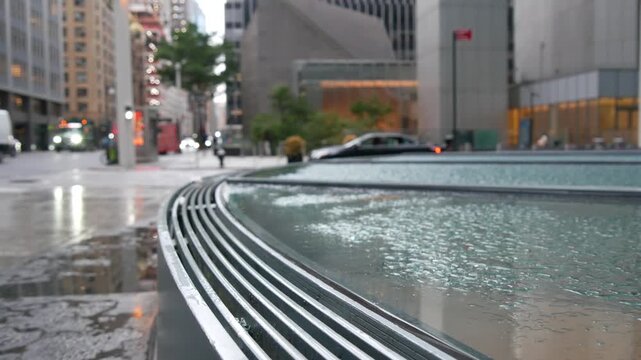 Manhattan Midtown East 53 street, New York City, United States. Yellow taxi car, Lexington avenue road traffic. Rainy day weather, drops on pavement, wet sidewalk in central business district. morning